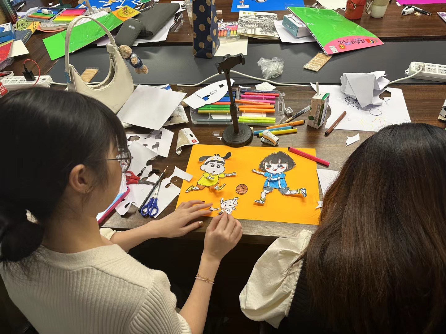 Students making paper characters in an art workshop