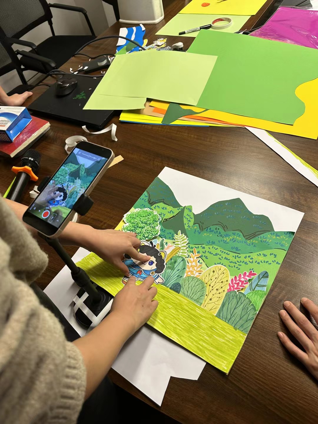 Student colouring a paper scene